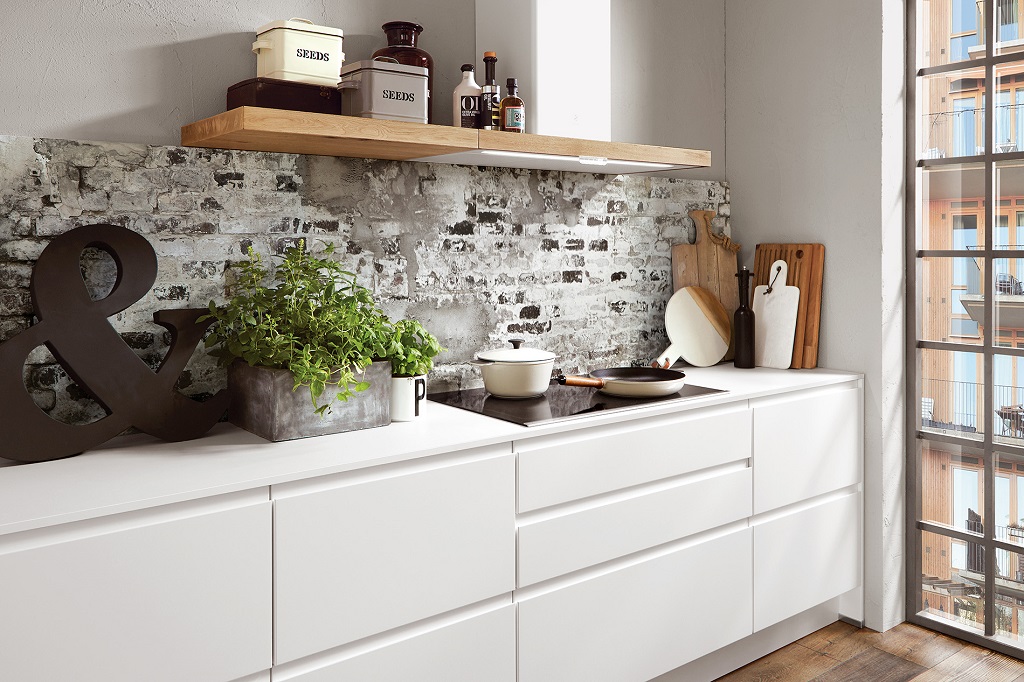 Detail of a white Nobilia kitchen with flat fronts and integrated grips
